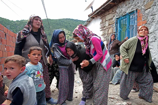 Relatives mourn during the funeral for the victims of a mining disaster on May 15, 2014 in Soma, a district in Turkey's western province of Manisa. Rescuers are still trying to reach parts of the coal mine in Soma, 480 km (300 miles) southwest of Istanbul, almost 48 hours after fire knocked out power and shut down the ventilation shafts and elevators, trapping hundreds underground. (Photo by Ahmet Sik/Getty Images)