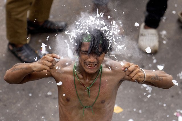 A Shiite Muslim breaks a light tube on his head during a Muharram procession in Lucknow, India, Wednesday, July 17, 2024. Muharram is the mourning month for Shiite Muslims in remembrance of the seventh century death of Imam Hussein, the grandson of the Islamic prophet Muhammad at the Battle of Karbala. (Photo by Rajesh Kumar Singh/AP Photo)