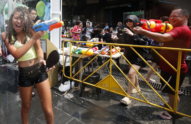People take part in a water gun battle as part of the annual Songkran festival, also known as water festival, the traditional Thai New Year celebrations, at the tourist spot of Khao San Road in Bangkok, Thailand, 13 April 2023. Thailand celebrates its first water-splashing Songkran festival following a three-year pause due to the COVID-19 pandemic. Songkran is celebrated with splashing water and putting powder on each other's faces as a symbolic sign of cleansing and washing away the sins from the old year. (Photo by Rungroj Yongrit/EPA)