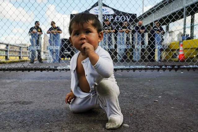 A Mexican one-year-old baby, who is awaiting her turn to seek asylum in the U.S. with her mother, is seen in front of the gates to the Gateway International Bridge in Matamoros, Mexico on October 10, 2019. (Photo by Veronica G. Cardenas/Reuters)