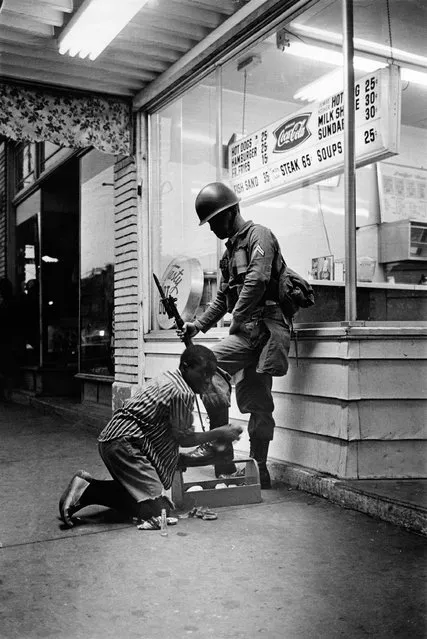 A soldier gets his boots shined during riots in Detroit, USA on July 1967. (Photo by Eddie Adams/The Guardian)
