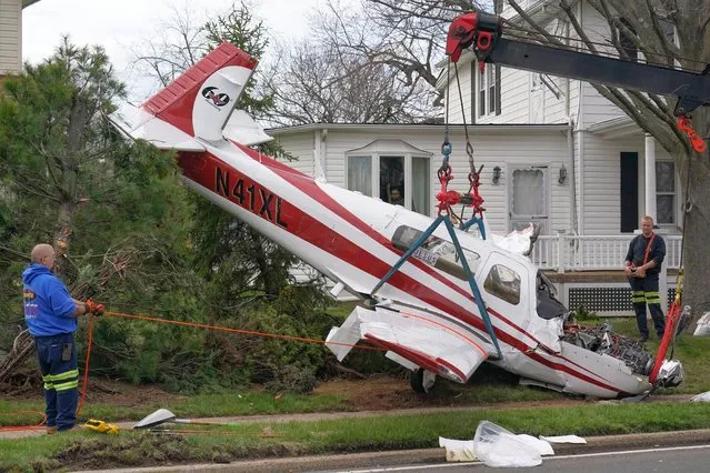 Emergency personnel work to remove a small plane that crashed in a residential neighborhood in Manville, N.J., Monday, April 4, 2022. Authorities say the small plane crashed in the front yard of a home in New Jersey, leaving one person aboard the aircraft injured. (Photo by Seth Wenig/AP Photo)