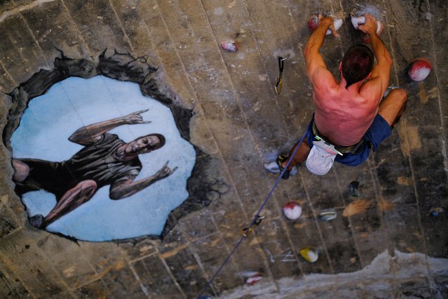 A man climbs at the Foixarda tunnel, a former road tunnel transformed into an urban, free-to-use climbing gym open at all times, equipped with thousands of holds, in Barcelona, Spain on June 29, 2024. (Photo by Nacho Doce/Reuters)