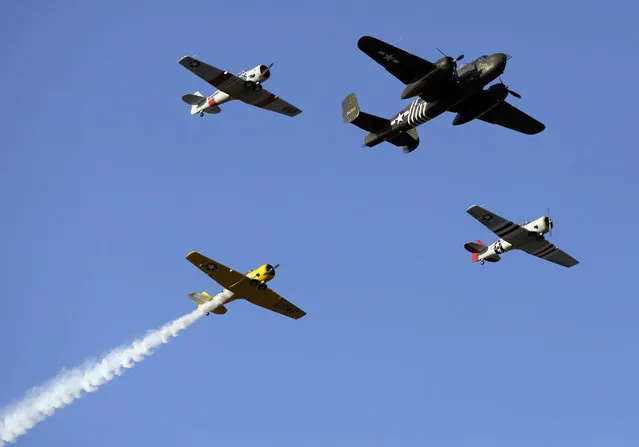 Vintage aircraft fly over the speedway during the playing of the national anthem before an IndyCar auto race at Texas Motor Speedway, Saturday, June 10, 2017, in Fort Worth, Texas. (Photo by Tony Gutierrez/AP Photo)
