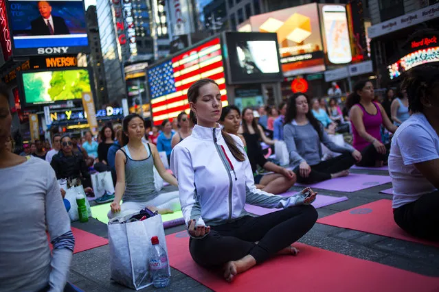 People practice yoga in Times Square as part of a Summer Solstice celebration in New York June 21, 2014. (Photo by Eric Thayer/Reuters)