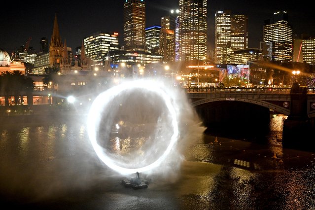 A light display titled “Constellation” by Studio Lemercier, where light is projected on invisible water particles to form shapes and intangible structures in the air resulting in 3D-like visuals, is viewed on Melbourne's Yarra River on August 29, 2024. (Photo by William West/AFP Photo)