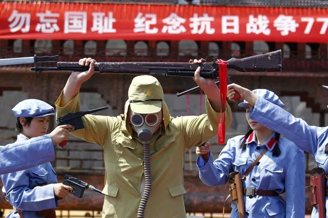 A group of Chinese women dressed in costumes depicting the famous Women's Detachment of the Red Army accept the surrender of a Japanese soldier (C) during a performance in Luanchuan, central China's Henan province on July 7, 2014, the 77th anniversary of the official start of war with Japan. (Photo by AFP Photo)