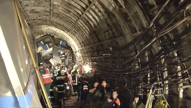 In this frame grab from video provided by the Russian Ministry for Emergency Situations, rescue teams work inside the tunnel in Moscow where a rush-hour subway train derailed Tuesday, July 15, 2014, killing at least 20 people and sending 150 others to the hospital, many with serious injuries, Russian officials said. Officials vigorously dismissed terrorism as a possible cause. (Photo by AP Photo/Russian Emergency Situation Ministry)