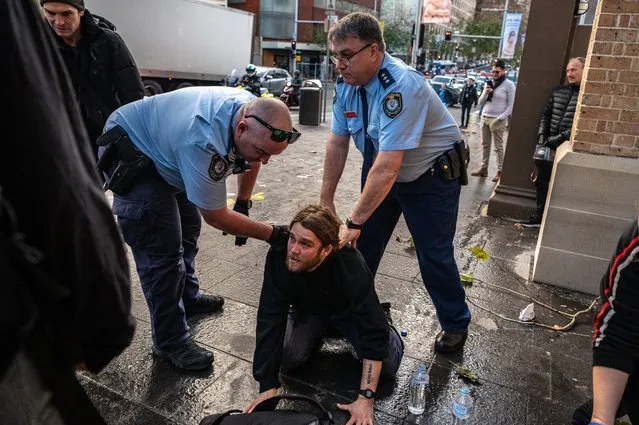 Police officers detain a protestor during a rally in Sydney. Climate activist group Blockade Australia stage a protest in Sydney, Tuesday, June 28, 2022. (Photo by Flavio Brancaleone/AAP Image)
