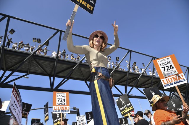 Demonstrators carry signs on the picket line outside Universal Studios on Friday, August 4, 2023, in Universal City, Calif. The actors strike comes more than two months after screenwriters began striking in their bid to get better pay and working conditions. (Photo by Richard Shotwell/Invision/AP Photo)