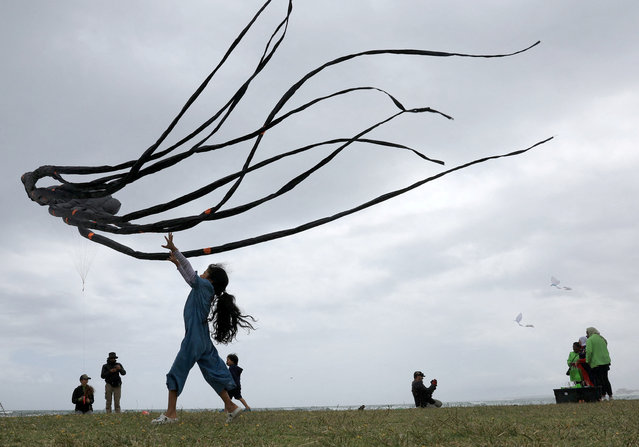 A girl plays with a kite at the 30th Cape Town International Kite Festival, an awareness campaign for World Mental Health Day where kite enthusiasts gather to fly colourful kites, participate in social activities, and raise funds for Cape Mental Health at Melkbosstrand, Cape Town, South Africa, on October 27, 2024. (Photo by Esa Alexander/Reuters)