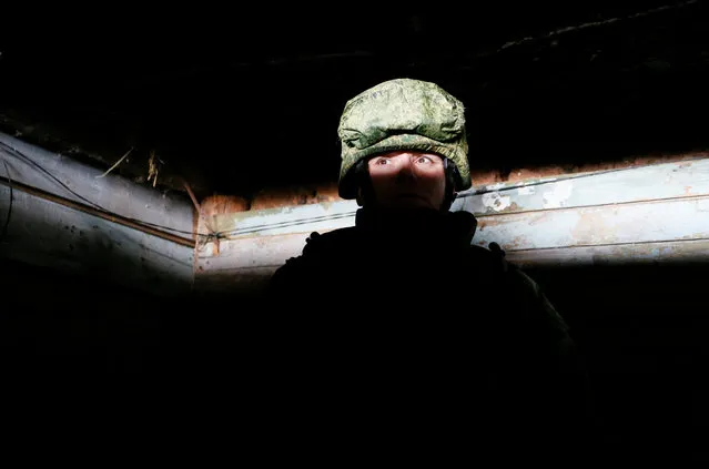 A militant of the self-proclaimed Donetsk People's Republic stands guard inside a dugout on the line of separation from the Ukrainian armed forces near Staromykhailivka (Staromikhailovka) settlement in Donetsk Region, Ukraine on January 23, 2020. (Photo by Alexander Ermochenko/Reuters)
