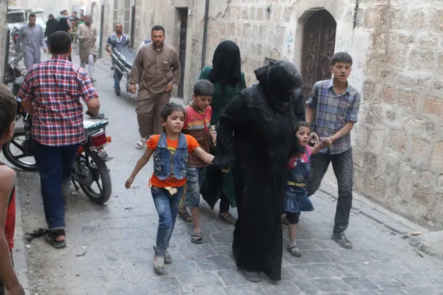 Women and children flee after an airstrike on Aleppo's rebel held Kadi Askar area, Syria July 8, 2016. (Photo by Abdalrhman Ismail/Reuters)