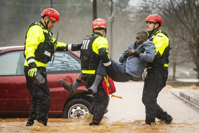 Winston-Salem Fire Department firefighters with the Rescue Task Force rescue Donald Harold from his home at Liberty Landing Apartments as flood waters rise around the building on Thursday, February 6, 2020 in Winston-Salem, N.C. (Photo by Andrew Dye/The Winston-Salem Journal via AP Photo)
