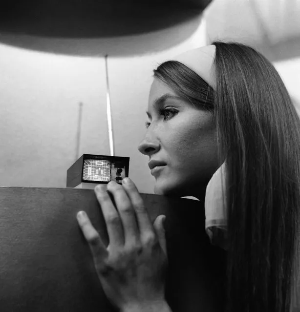 A pocket size television set that can go anywhere and claims to be the world's smallest TV, was presented at Earls Court, London on September 1, 1966. Miss Bari Lyn Chadwich of Cheshire looks at the Sinclair Micro vision set, designed by Clive Sinclair, a 26 year old Cambridge electronic engineer. Britain's midget TV set is powered by six ordinary penlight batteries. The rectangular face plate of the cathode tube has a diagonal measurement of two inches. The circuit uses 20 transistors, and covers channels 1 to 13 in Britain. (Photo by AP Photo)