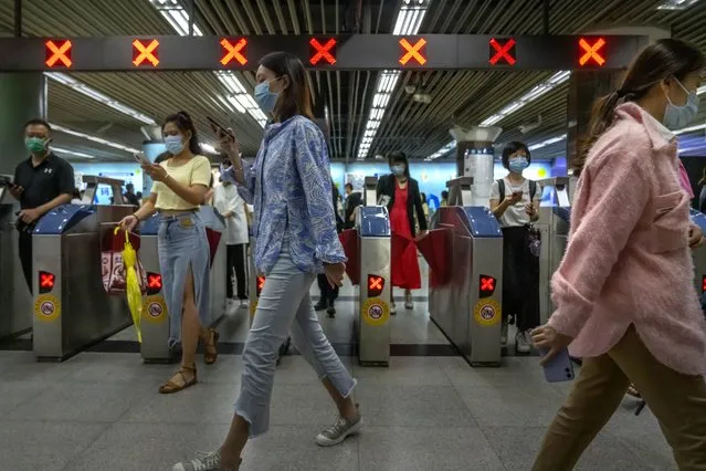 Commuters walk through a subway station during the morning rush hour in the central business district in Beijing, Tuesday, August 9, 2022. China's 11 million university graduates are struggling in a bleak job market this summer as repeated shutdowns under China's anti-COVID lockdowns forced companies to retrench and driven many restaurants and other small employers out of business. (Photo by Mark Schiefelbein/AP Photo)