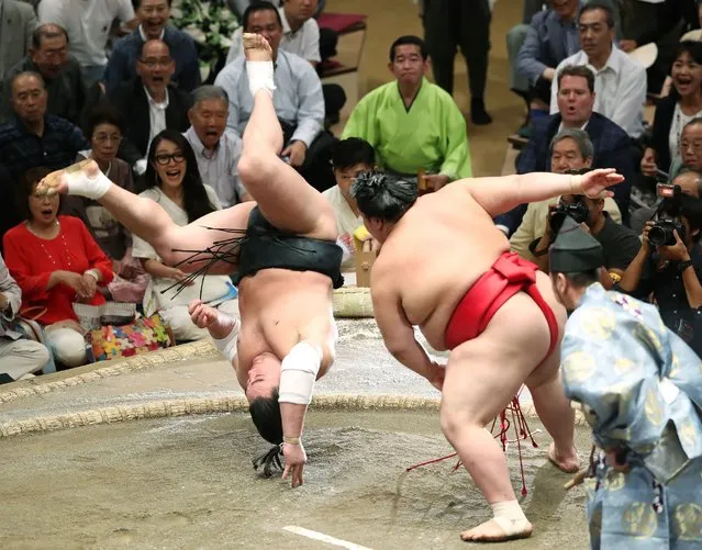 Grand sumo champion, or “yokozuna”, Harumafuji (L) of Mongolia somersaults over to lose his bout against Onosho of Japan (R) on the fifth day of the 15-day Autumn Grand Sumo Tournament in Tokyo on September 14, 2017. (Photo by AFP Photo/JIJI Press)