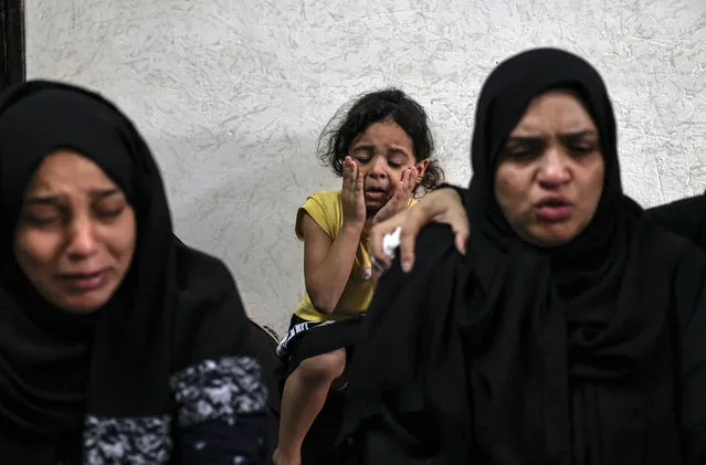 Relatives mourn during the funeral of Palestinian Anas Anshasi, 22, after he succumbed to his injuries sustained in last week's Israeli air strikes, in Khan Yunis in the southern Gaza Strip, on August 12, 2022. (Photo by Said Khatib/AFP Phoot)