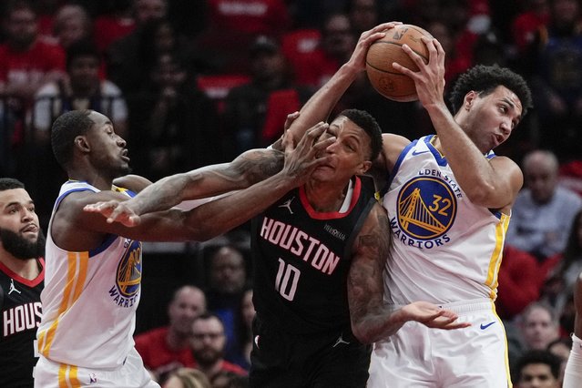Golden State Warriors forward Jonathan Kuminga (00), forward Trayce Jackson-Davis (32), and Houston Rockets forward Jabari Smith Jr. (10) vie for the ball during the first half of an Emirates NBA cup tournament quarterfinal basketball game in Houston, Wednesday, December 11, 2024. (Photo by Ashley Landis/AP Photo)
