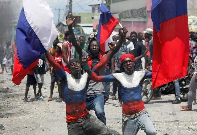 Demonstrators holding Russian flags and with their torsos painted in the colors of the flag take part in a protest against insecurity, inflation and to call for the resignation of Prime Minister Ariel Henry, in Port-au-Prince, Haiti on September 7, 2022. (Photo by Ralph Tedy Erol/Reuters)