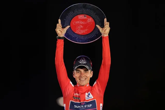 Belgian Remco Evenepoel of Quick-Step Alpha Vinyl holds up his trophy on the podium after winning La Vuelta cycling race in Madrid, Spain, Sunday, September 11, 2022. (Photo by Manu Fernandez/AP Photo)