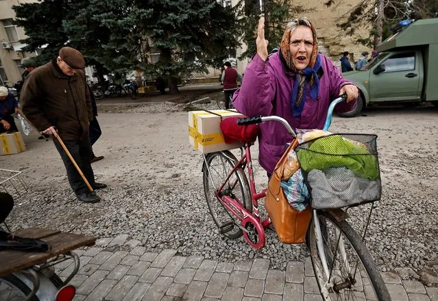 A local resident wheels her bicycle after she received humanitarian aid, amid Russia's invasion of Ukraine, in the recently liberated town of Lyman, Donetsk region, Ukraine on October 5, 2022. (Photo by Zohra Bensemra/Reuters)