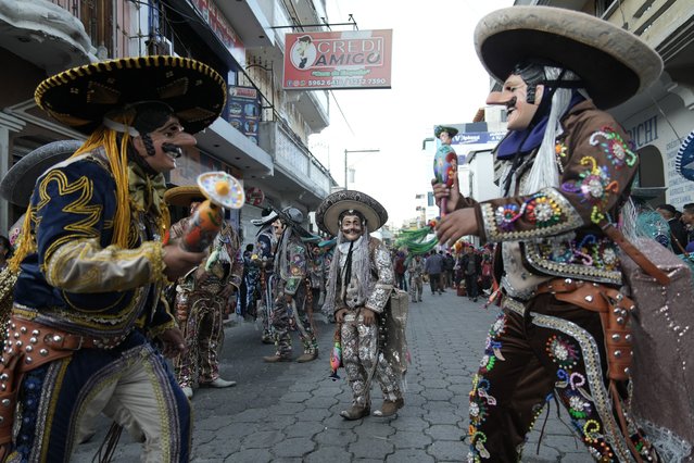 Members of a Guatemalan dance group dressed in traditional clothes and using masks perform the traditional “El Torito” (Little Bull) dance during the procession in honor of Santo Tomas in Chichicastenango, Guatemala, on December 20, 2023. (Photo by Emmanuel Andres/AFP Photo)