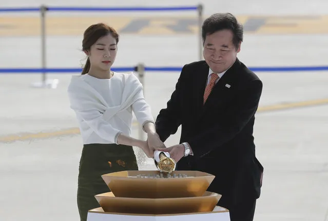South Korean Prime Minister Lee Nak-yon, right, and former South Korean Olympic figure skating champion Yuna Kim, light the cauldron with the Olympic Flame during the Olympic Flame Arrival ceremony at Incheon International Airport in Incheon, South Korea, Wednesday, November 1, 2017. (Photo by Lee Jin-man/AP Photo)