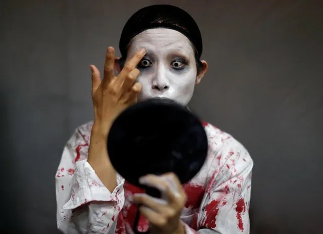 Actor Ayaka Imaide prepares a zombie makeup before her performance at a drive-in haunted house show by Kowagarasetai (Scare Squad), for people inside a car in order to maintain social distancing amid the spread of the coronavirus disease (COVID-19), at a garage in Tokyo, Japan on July 3, 2020. (Photo by Issei Kato/Reuters)