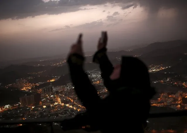 A Muslim pilgrim raises her hands to pray after visiting Hera cave, where Muslims believe Prophet Mohammad received the first words of the Koran through Gabriel, at the top of Mount Al-Noor during the annual haj pilgrimage in the holy city of Mecca, September 21, 2015. (Photo by Ahmad Masood/Reuters)