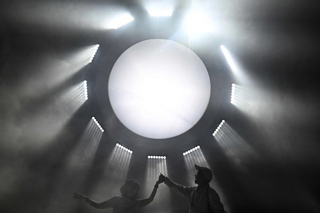 Visitors pose for pictures with light installations at SangSom Moonlab, an interactive art exhibition at One Bangkok on March 17, 2025. (Photo by Lillian Suwanrumpha/AFP Photo)