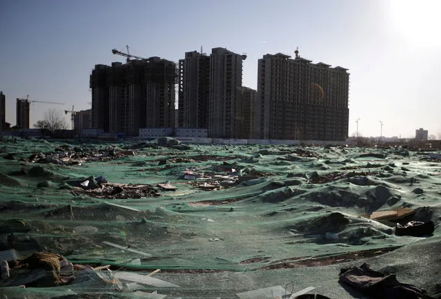 The land is covered after residents were required to move out from the low-cost dwellings near apartment blocks under construction at a village, which is mainly inhabited by migrant workers, in Tongzhou district of Beijing, China December 16, 2017. (Photo by Jason Lee/Reuters)