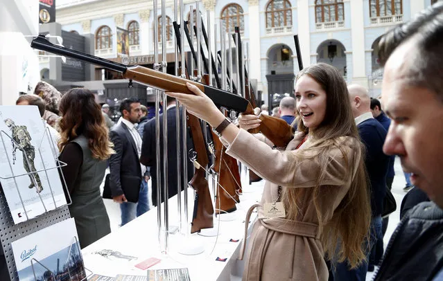 A visitor aims with a rifle on display at the Kalashnikov Group pavilion during the ARMS & Hunting 2015 International Exhibition at the Gostinniy Dvor exhibition centre in Moscow, Russia, October 2, 2015. (Photo by Maxim Shipenkov/EPA)