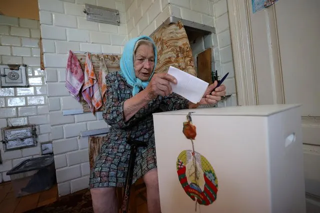An elderly woman casts her vote into a mobile ballot box in a house as members of an electoral commission visit local residents during the presidential election in the settlement of Nizhniye Pogorany near Grodno, Belarus on August 9, 2020. (Photo by Reuters/Stringer)