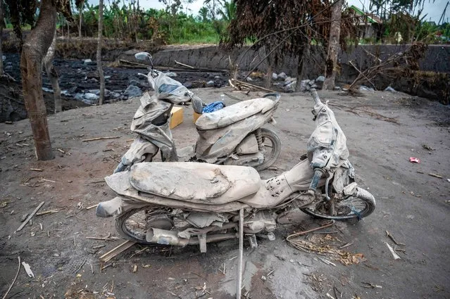 Damaged motorcyles are covered in ash at Kajar Kuning village in Lumajang on December 7, 2022, following the volcanic eruption of mount Semeru on December 4. (Photo by Juni Kriswanto/AFP Photo)