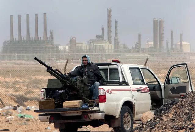 In this March 5, 2011 file photo, an anti-government rebel sits with an anti-aircraft weapon in front an oil refinery in Ras Lanouf, eastern Libya. The United States France, Germany, Italy, Spain and Britain have called upon forces loyal to a Libyan general to withdraw from three eastern oil terminals seized earlier this week, in a statement Monday, September 13, 2016. The oil-rich North African country slid into chaos after the 2011 uprising that toppled and killed Moammar Gadhafi. (Photo by Hussein Malla/AP Photo)