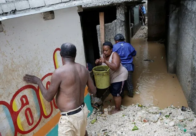 Residents take buckets with water out of a house that has been flooded during the passage of Tropical Storm Laura, in Port-au-Prince, Haiti on August 23, 2020. (Photo by Andres Martinez Casares/Reuters)