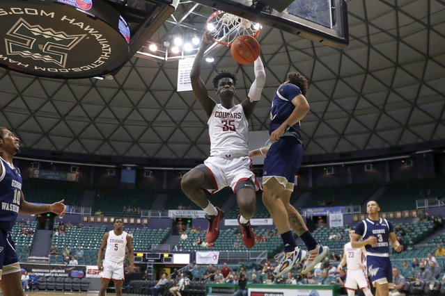 Washington State forward Mouhamed Gueye (35) dunks next to George Washington guard Maximus Edwards during the second half of an NCAA college basketball game Thursday, December 22, 2022, in Honolulu. (Photo by Marco Garcia/AP Photo)