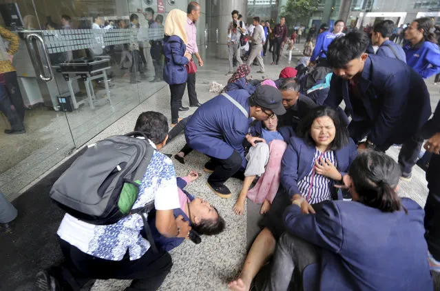 Injured persons are evacuated from the Jakarta Stock Exchange tower in Jakarta, Indonesia, Monday, January 15, 2018. A structure inside the tower collapsed Monday, injuring at least several people and forcing a chaotic evacuation. (Photo by AP Photo/Stringer)