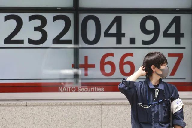 A man stands by an electronic stock board of a securities firm in Tokyo, Wednesday, September 2, 2020. Asian shares were mixed on Wednesday after another U.S. rally spurred by positive economic data, even while the coronavirus pandemic has regions around the world battling recessions. (Photo by Koji Sasahara/AP Photo)