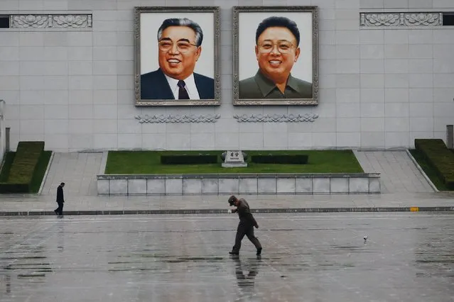 A soldier walks under portraits of North Korea's founder Kim Il-sung (L) and former leader Kim Jong-il at Pyongyang's main square October 11, 2015. (Photo by Damir Sagolj/Reuters)