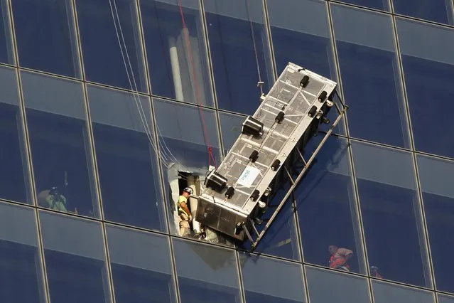 Workers look out at a broken scaffolding that had stranded window washers earlier on the side of 1 World Trade Center in New York November 12, 2014. Two window washers caught on dangling scaffolding on the 69th floor of New York City's 1 World Trade Center were pulled to safety on Wednesday through a window cut in the tallest U.S. skyscraper, a building official said. (Photo by Mike Segar/Reuters)