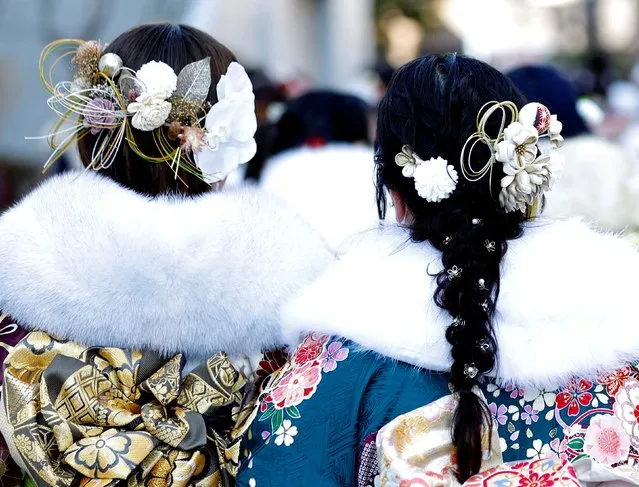 Kimono-clad young women with decorations in their hair leave a venue after their Coming of Age Day celebration ceremony in Yokohama, Japan on January 9, 2023. (Photo by Kim Kyung-Hoon/Reuters)
