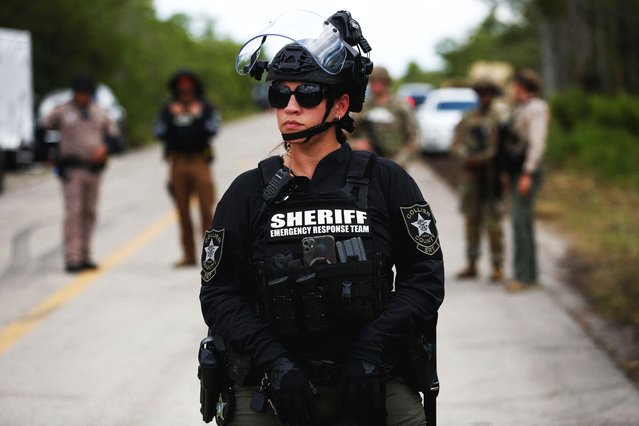 A member of Collier County Sheriff’s Office Emergency Response Team monitors protest at an entrance road of a temporary migrant detention center nicknamed “Alligator Alcatraz” on the day of a visit by President Donald Trump in Ochopee, Florida, on July 1, 2025. (Photo by Octavio Jones/Reuters)