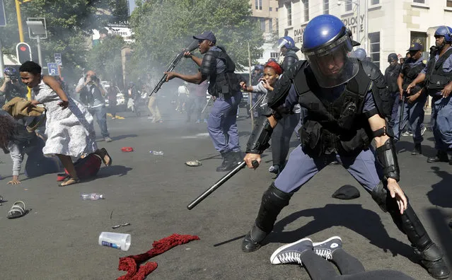 Students run for cover as police fire stun grenades and rubber bullets in an attempt to disperse them, during their protest for free education in Johannesburg, South Africa, Wednesday, September 21, 2016. A leading university in South Africa has closed for the rest of the week because of violence by protesters demanding free education across the country. (Photo by Themba Hadebe/AP Photo)