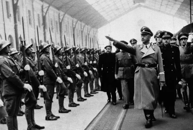 Heinrich Himmler, giving the Nazi Salute, chief of Hitler's police, is seen in Madrid Railway Station on arrival for his visit with Count Mayalde, Chief of Spanish Department of Security, October 20, 1940.  Mayalde reviews the honor guard, and immediately behind him is Ramon Serrano Suner, brother-in-law of Generalissimo Francisco Franco. (Photo by AP Photo)