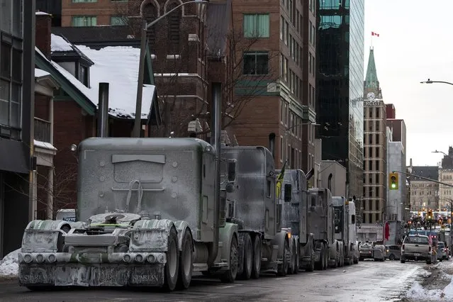 Trucks are parked on Metcalfe Street as a rally against COVID-19 restrictions, which began as a cross-country convoy protesting a federal vaccine mandate for truckers, continues in Ottawa, Ontario, on Sunday, January 30, 2022. Thousands of antivaccine protesters descended on Canada’s capital of Ottawa in frigid temperatures to protest vaccine mandates, masks and restrictions over the weekend and some remain, blocking traffic around Parliament Hill in what has been the biggest pandemic protest in the country to date.(Photo by Justin Tang/The Canadian Press via AP Photo)