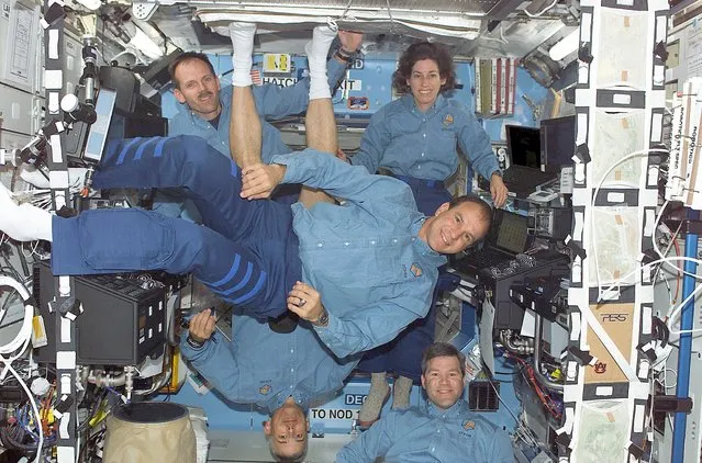 Space Shuttle Atlantis Astronauts, STS-110 mission commander Michael J. Bloomfield (C-foreground), pilot Stephen N. Frick (bottom right), Steven L. Smith (TOPL), Ellen Ochoa, and Lee M. E. Morin (UPSIDE DOWN)pose in the International Space Station's Destiny laboratory April 13, 2002, in this NASA handout image. (Photo by Reuters/NASA)