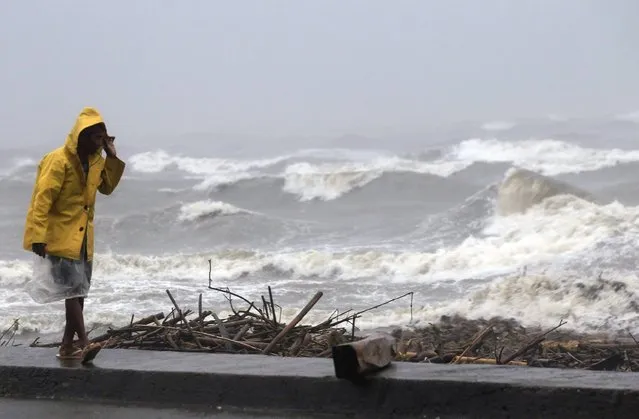 A man walks along the coast at a port, after heavy rain and strong winds brought by typhoon Hagupit battered Atimonan town, Quezon province, south of Manila, December 8, 2014. (Photo by Romeo Ranoco/Reuters)