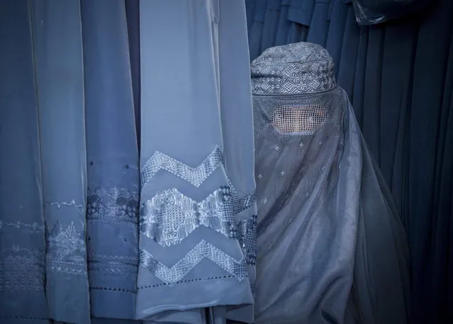 In this Thursday, April 11, 2013 photo, an Afghan woman peers through the  the eye slit of her burqa as she waits to try on a new burqa in shop in the old town of Kabul, Afghanistan. (Photo by Anja Niedringhaus/AP Photo)